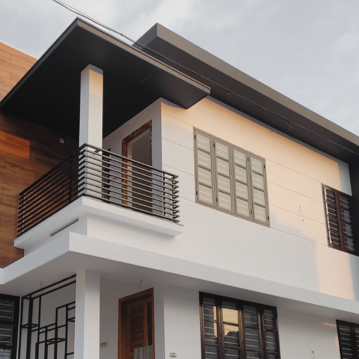 White residence with warm-lit balcony at dusk